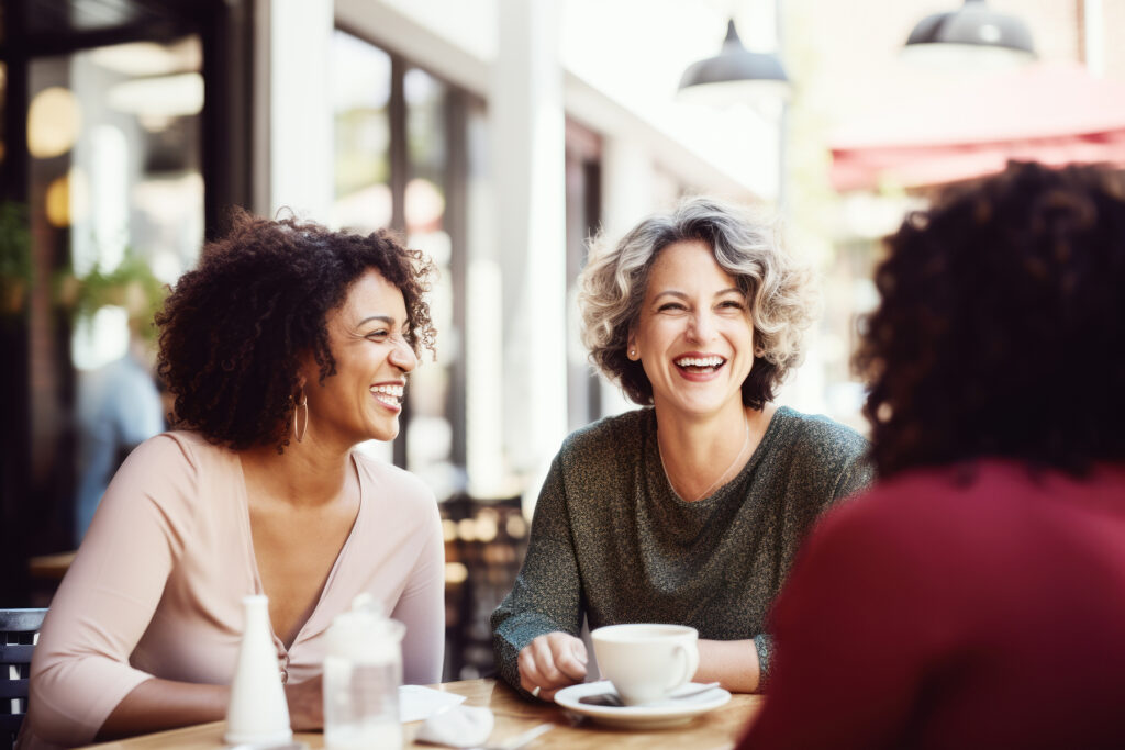 Happy smiling middle aged female friends sitting in a café laug